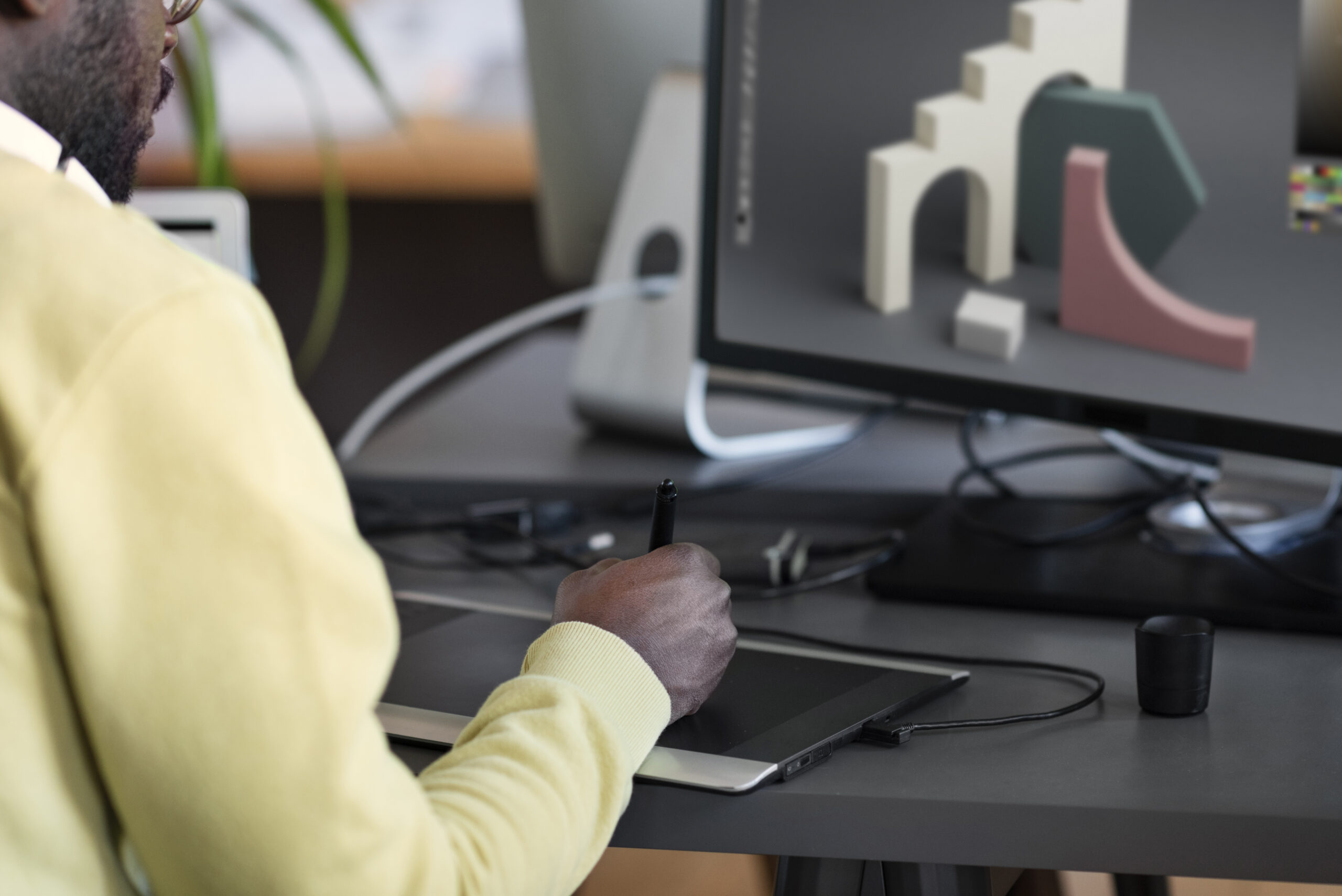 esigner travaillant sur un projet 3D avec une tablette graphique.